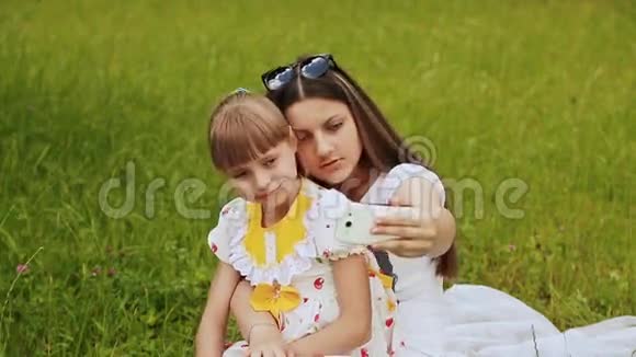 两个女孩在草地上做自拍视频的预览图
