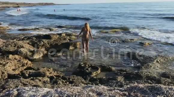穿比基尼的年轻女子在海滨散步视频的预览图