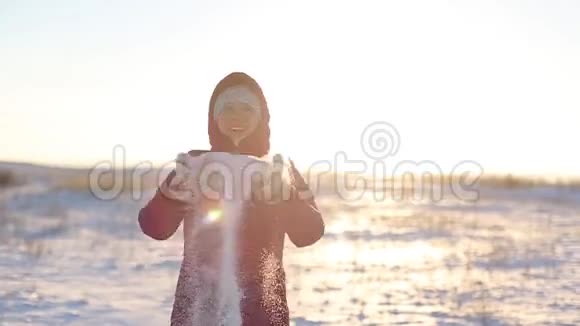 女孩在霜冻的早晨扔雪快乐而微笑视频的预览图