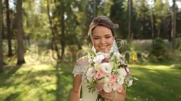 在云杉林中一位美丽得令人难以置信的新娘她有一束鲜花视频的预览图