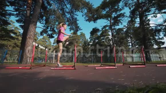 一个女跑步者跳过障碍物跑步前热身视频的预览图