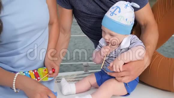 在户外咬玩具的宝宝好爸爸和妈妈在游艇上照顾儿子视频的预览图
