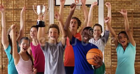 高中学生在篮球场上捧着奖杯欢呼视频的预览图