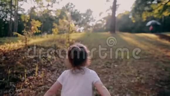 一个快乐的小女孩在阳光明媚的夏日在大自然的山上奔跑慢影后景视频的预览图