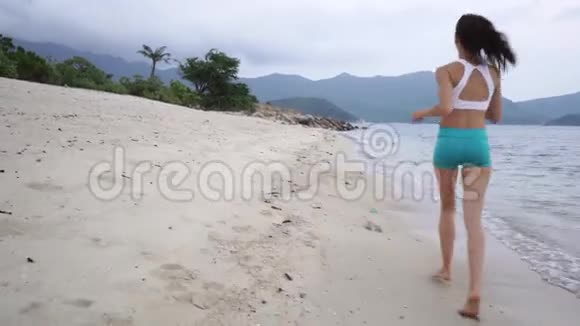 穿着白色上衣在海滩上奔跑的女人视频的预览图
