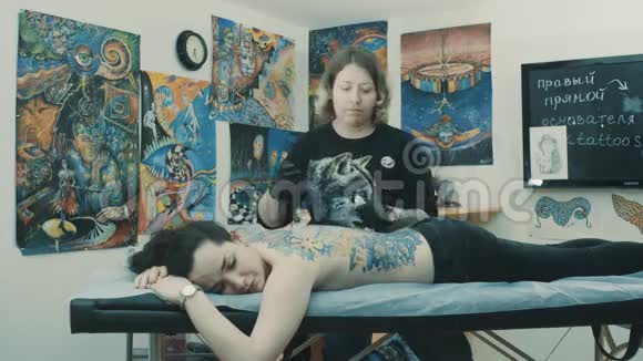 纹身师傅按摩客户的背部视频的预览图