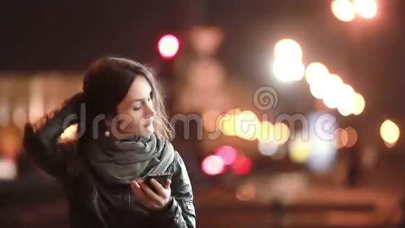 漂亮的年轻女人打电话她在寒冷的夜晚在街上打电话现代技术视频的预览图