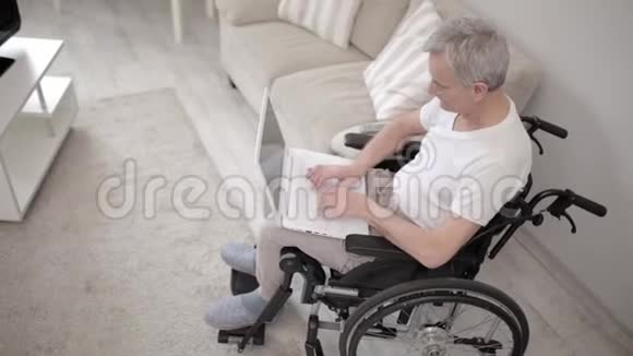 坐轮椅的残疾人在笔记本电脑上打字视频的预览图