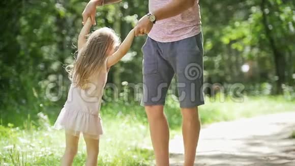 在公园里和爸爸在一起的小女孩爸爸在旋转她的小女孩慢动作视频的预览图