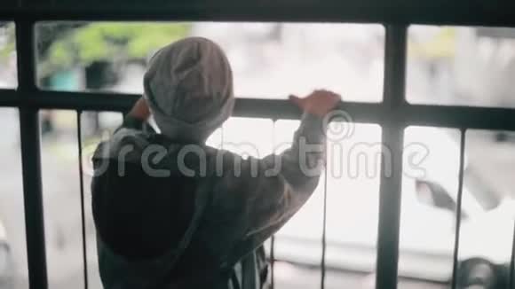 一个小男孩靠在桥栏杆上的后视图把他的脸转向相机和背部视频的预览图