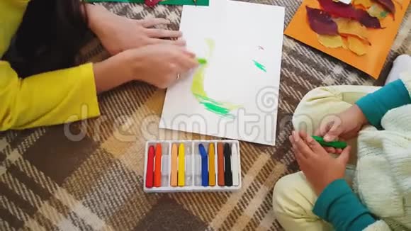 年轻的母亲和女儿在白纸上画油浆字秋天做一个贴花小女孩视频的预览图