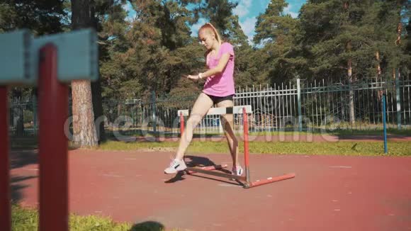 一个女跑步者跳过障碍物跑步前热身视频的预览图