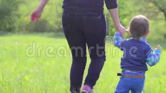 妈妈和孩子在草地上奔跑视频的预览图
