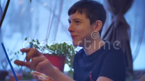 小男孩吃披萨坐在咖啡馆快餐慢动作视频视频的预览图