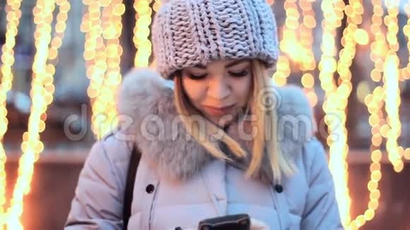 亚洲女孩正在你的智能手机上打字黄色花环的背景微笑快乐美丽视频的预览图
