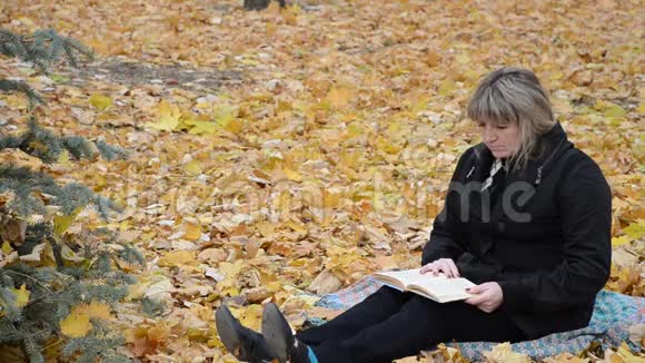 一个女人在秋天公园看书视频的预览图