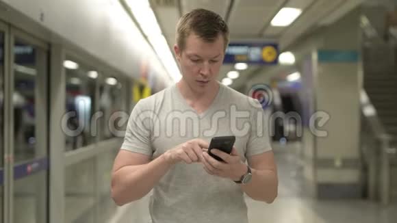 年轻的快乐游客在曼谷的地下火车站用电话视频的预览图