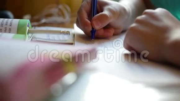 孩子做家庭作业在桌上的特写上写一本书视频的预览图