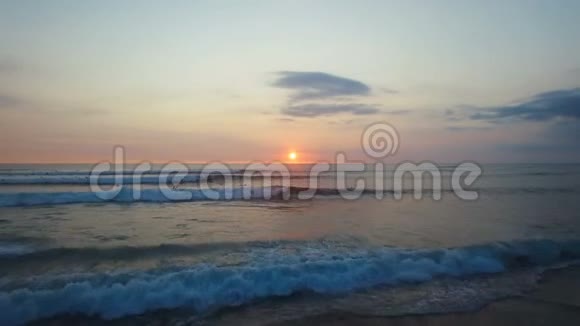 在日落时飞越美丽的海浪和冲浪空中摄影视频的预览图