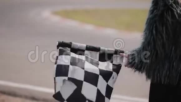 一个女人的后景是举着一面挥舞的种族检查旗卡丁车赛道视频的预览图