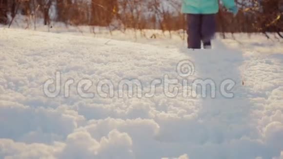 童腿在初雪的夕阳下冬天的欢乐视频的预览图