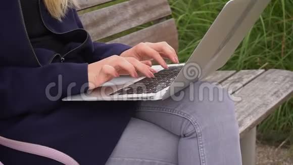 在外面的笔记本电脑键盘上慢动作地合上打字机的手视频的预览图
