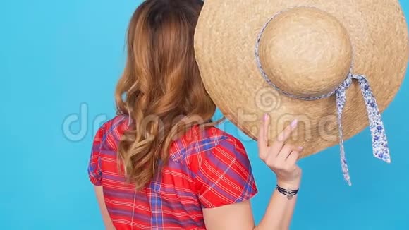 戴着蓝色背景帽子的年轻女子视频的预览图