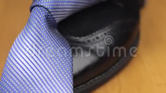 蓝色打结的领带系在一个黑人鞋子上视频的预览图