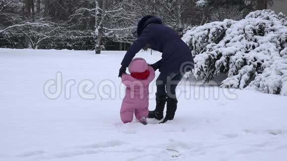 小女孩学习她妈妈学习在冬天的雪上行走4K视频的预览图