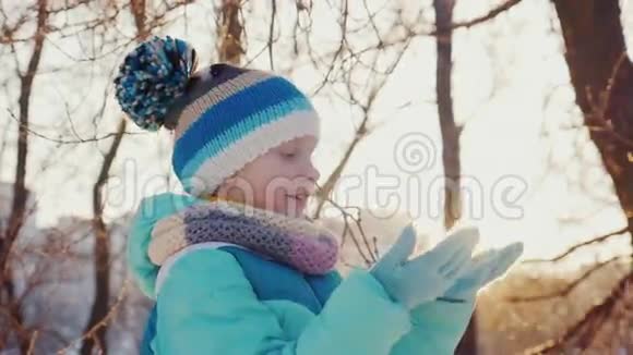 一个孩子在阳光下享受冬天检查树枝上的霜冻视频的预览图