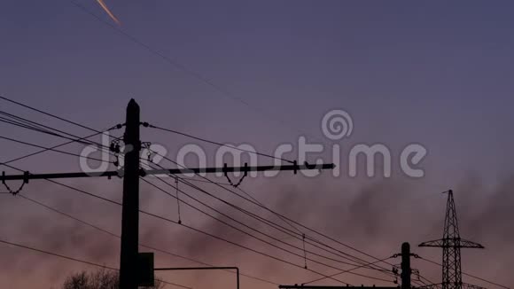 高压电塔来自工厂的黑烟和飞机在夜空中的踪迹4k视频的预览图