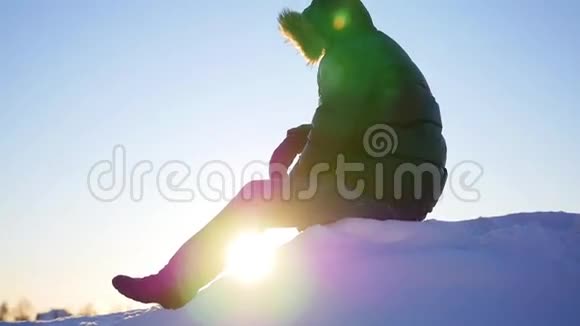 那个家伙坐在雪坡上挥手打招呼冬天的雪景户外运动视频的预览图