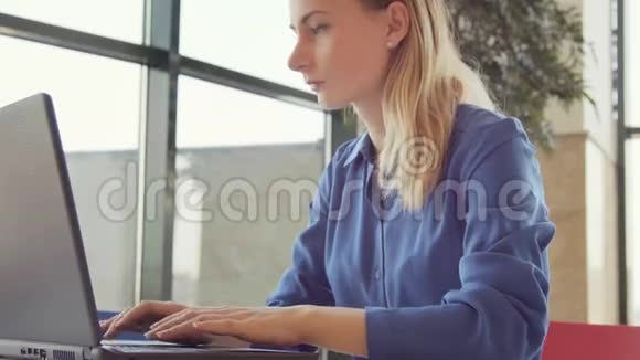 年轻女性在办公室打喷嚏时使用笔记本电脑时的过敏和健康问题视频的预览图