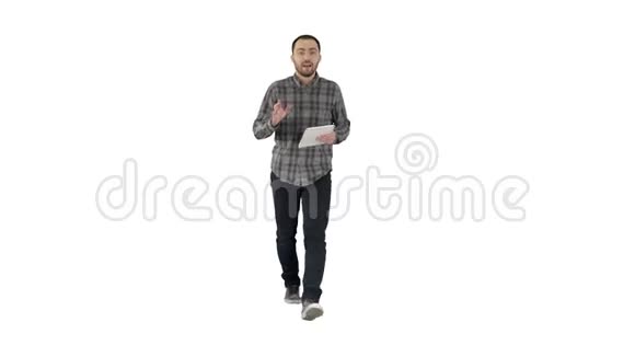 微笑的男人带着平板走路在白色的背景上和相机交谈视频的预览图
