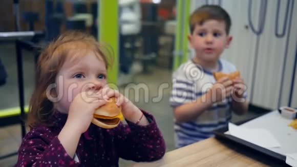 为小女孩和男孩准备美味的汉堡和炸薯条有趣的孩子在快餐店里玩美食视频的预览图