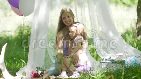 妈妈和女儿在公园里拥抱野餐和生日视频的预览图