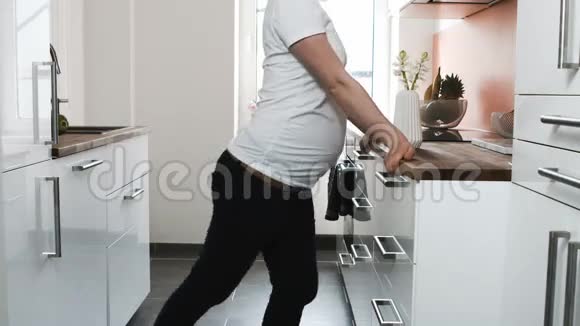 怀孕的女人在厨房里伸展视频的预览图