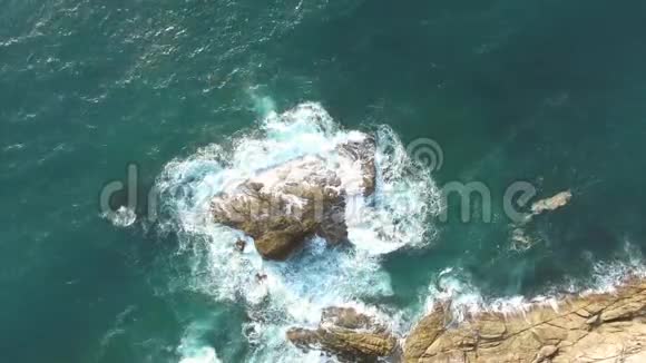 大海中的大岩石对抗白色的海浪热带4K鸟瞰图视频的预览图