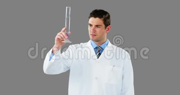 医生用数码屏幕检查试管中的化学物质视频的预览图