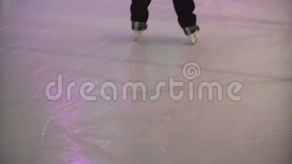 近距离观看人群双脚在室内冰场滑冰上面有人造冰和彩色光视频的预览图