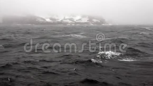南极海洋雪岩背景下的波浪和雾视频的预览图