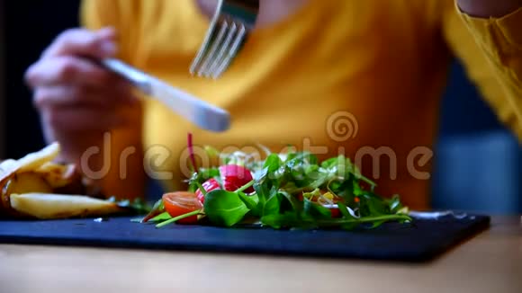 女人吃她的蔬菜沙拉餐厅视频的预览图