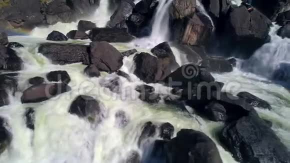 空中拍摄瀑布溅水与岩石流动的水特写视频的预览图