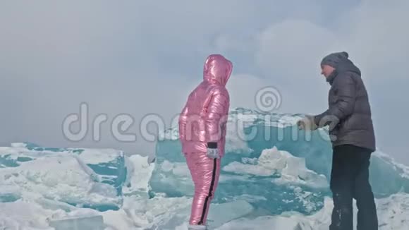 在冰封的湖面上年轻夫妇在冬天散步时玩得很开心情侣们玩得很开心笑了视频的预览图