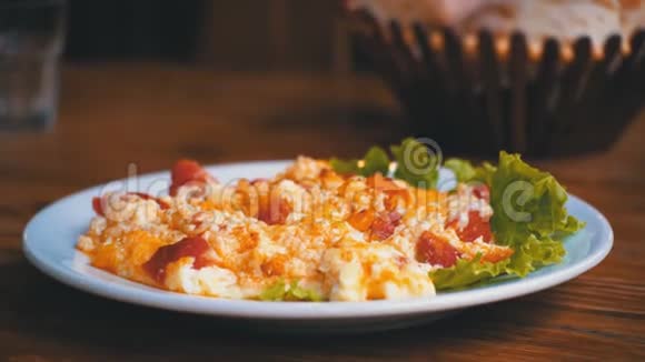 在餐厅的木桌上放一盘带有番茄奶酪和草药的格鲁吉亚欧梅视频的预览图