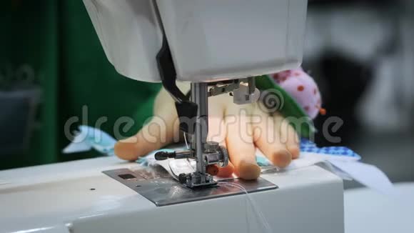 特写女孩缝在缝纫机上把组织埋在针下视频的预览图