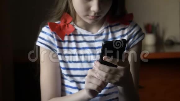 微笑的女孩在家里的智能手机上发短信视频的预览图