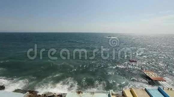波浪在堤岸飞溅在蓝天上喷洒一滴玻璃化的海水风暴视频的预览图