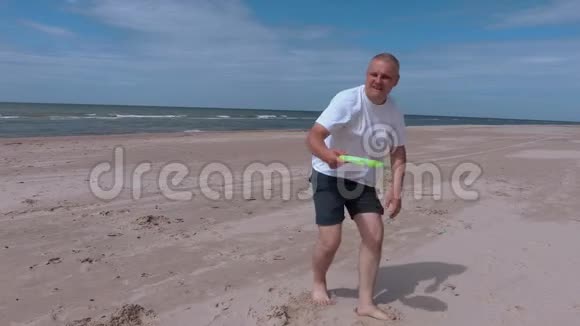 在海滩上玩飞盘放松的人视频的预览图