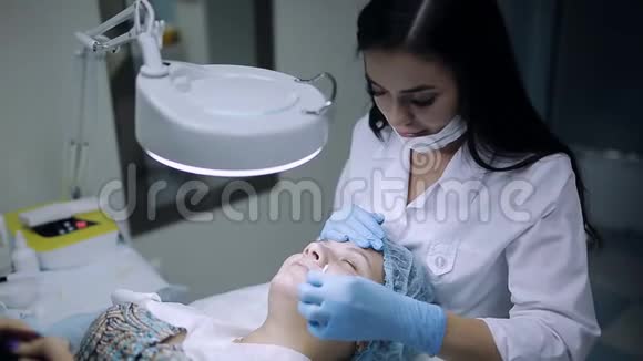 医生美容师在美容室治疗痤疮时在面部使用防腐剂视频的预览图